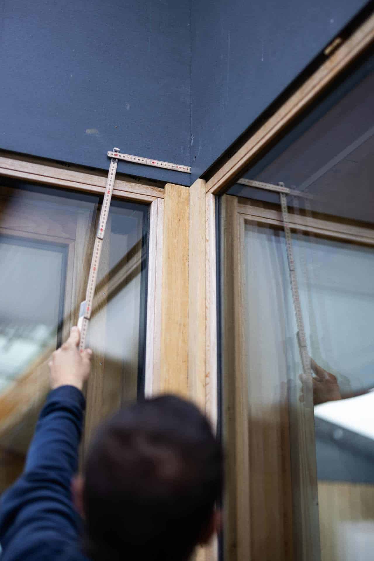 Tømrer i Lyngby på arbejde og måler vinduer inden udskiftning